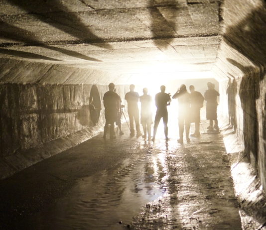 ‘Defund the police’ movement, COVID-19 vaccinations and combating gang violence Gang violence: Group of people in hoodies and pants stand facing a bright light at the far end of a fog-filled tunnel