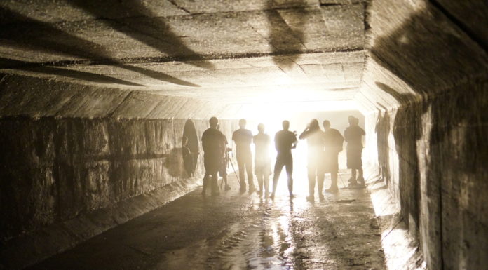 ‘Defund the police’ movement, COVID-19 vaccinations and combating gang violence Gang violence: Group of people in hoodies and pants stand facing a bright light at the far end of a fog-filled tunnel