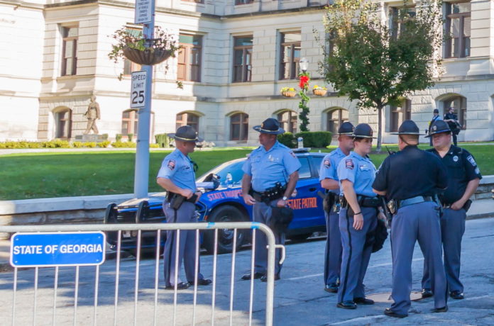 Trooper recruitment: Georgia state troopers stand in street outside the Georgia Capitol building behind a street barrier.