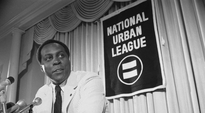 Vernon Jordan, activist, former Clinton adviser, has died Vernon Jones at press conference in 1977: a Black man wearing white seersucker suit and dark tie standing at podium speaking into microphones