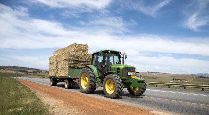 New law says when you must pull over for Georgia tractors Tractor Right-of-Way Law: Green tractor wit trailler hauling hay bales on public road