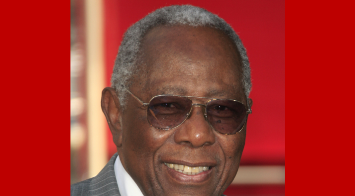 Atlanta school replacing KKK leader’s name with Hank Aaron’s Hank Aaron headshot of smiling, older, gray-haired Black man wearing wire-rim aviator glasses and gray pinstripe suit with white shir and navy tie