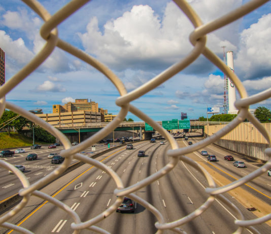 6 killed, 10 hurt in fiery van crash on Georgia interstate cars driving on 12-lane Georgia Interstate seen through chainlink fencing