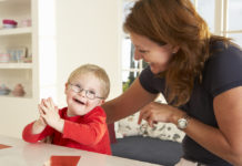 New Georgia law to ban discrimination in organ transplant process woman with brown hair wering black top and young toddler with blonde hair and glasses wearing red shirt sit at white kitchen counter