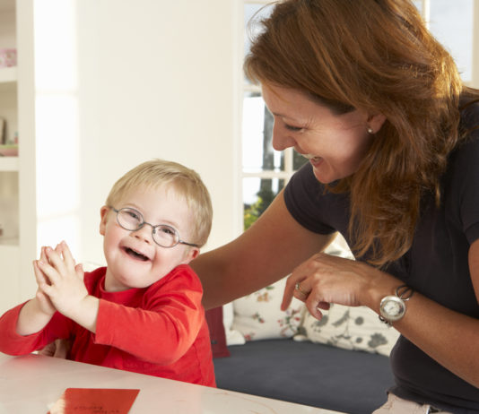 New Georgia law to ban discrimination in organ transplant process woman with brown hair wering black top and young toddler with blonde hair and glasses wearing red shirt sit at white kitchen counter