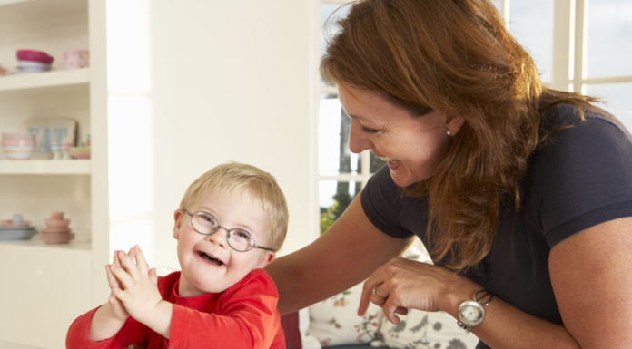 New Georgia law to ban discrimination in organ transplant process woman with brown hair wering black top and young toddler with blonde hair and glasses wearing red shirt sit at white kitchen counter
