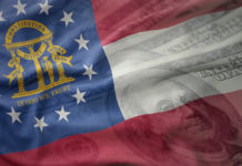 Kemp signs $27.3B state budget, will block police raises colorful waving flag of georgia state on a american dollar money background