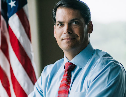 Georgia’s Lt. Governor won’t run again after taking on Trump Lt. Governor Geoff Duncan headshot -dark-haired man poses with arms crossed wearing light blue shirt and red tie in front of American flag