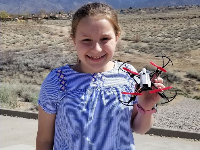Georgia girls' STEM program:; young blonde girl in blue bouseholds her drone
