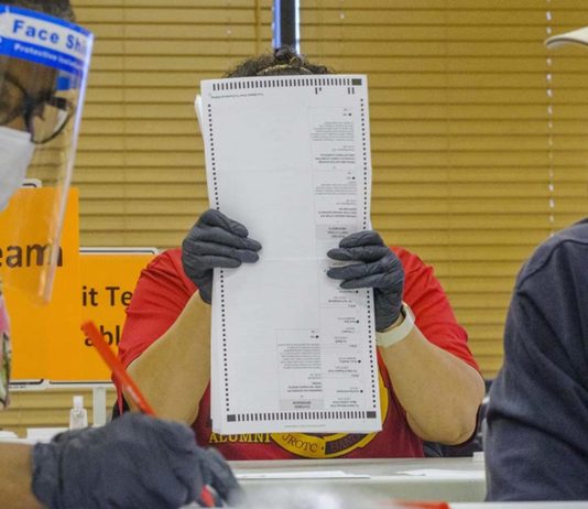 Here’s how Georgia could conduct a forensic audit of November’s election Three poll workers wearing gloves and masks counting ballot sheets