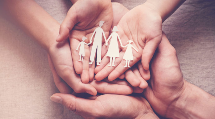 Georgia establishing new therapeutic foster care program Therapeutic foster care: Hands palms up overlapping holding paper cutout of 2 adults with 2 children holding hands