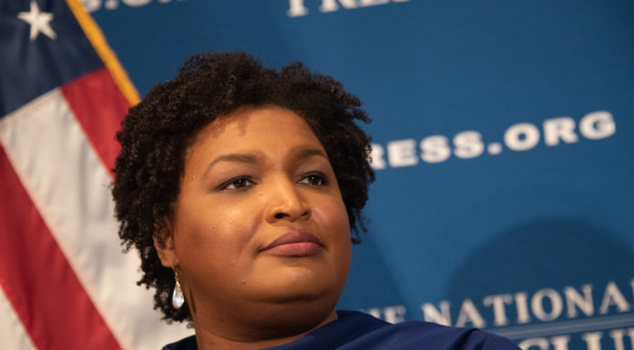 Georgia Democrats seize new power, run for statewide offices Stacey Abrams in front of US flag giving speech