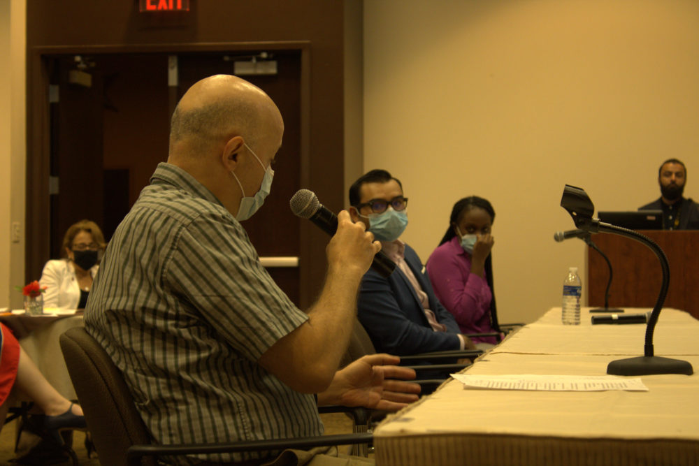 Dr. Riad talking at a table to two other people in mask