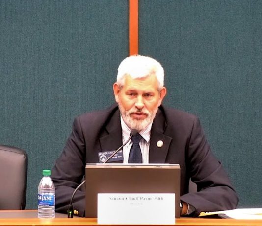 Senate Study Committee holds first meeting on Age of Mandatory Education White man in black blazer speaks into small microphone