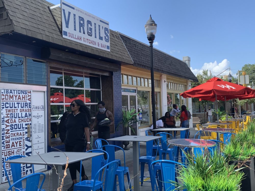 people walking infront of blue chairs in parklet 