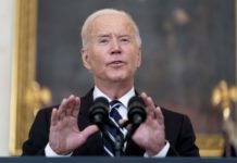 Federal mandate takes vaccine decision off employers’ hands feds mandate vaccine: Pres Biden - older, grey-haired man - speaking into microphone wearing dark suit, white shirt and navy striped tie