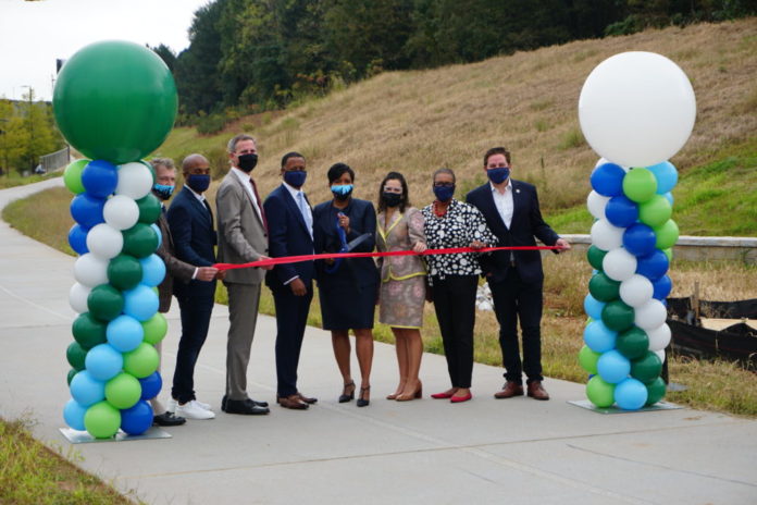 seven people holding a ribbon for a ribbon cutting