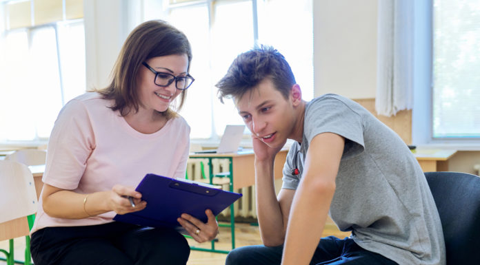 Georgia schools counselors warn of lack of staffing and support boy with gray shirt sitting with lady with glasses talking to him holding blue folder
