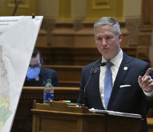 Georgia Senate GOP passes map to retain Republican majority GA Senate redistricting debate: White man with short gray hair in a navy blue suit standing with a blue tie and white shirt pointing his finger to the left standing behind a podium with a georgia color coded redistricting map in front of him