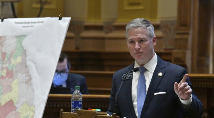 Georgia Senate GOP passes map to retain Republican majority GA Senate redistricting debate: White man with short gray hair in a navy blue suit standing with a blue tie and white shirt pointing his finger to the left standing behind a podium with a georgia color coded redistricting map in front of him
