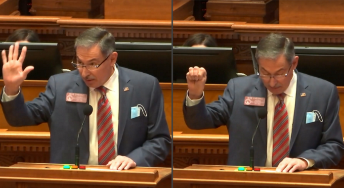 Signal for Help: Side-by-side picture ofGrey haired man in grey suit sitting at wood deck with raised right hand raised. In left side shwing th open palm psotion and right side showing closed fist position of the Signal for Help.