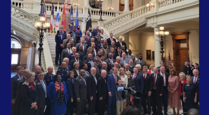 Governor and lawmakers honor veterans Georgia Capitol Senators honor veterans: Over 80 men and women in business attire on the Georgia Capitol lobby steps facing multiple photographers' cameras seen in foregroundgraphers