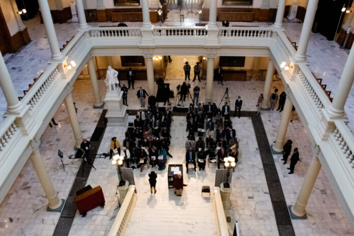 overview of lawmakers and Georgia leaders gathering at bottom of Capitol staircase.