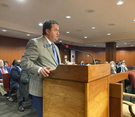 Bill: Give Georgia parents way to quash school materials white man with dark black hair, speaking into brown podium with grey blazer, blue pants and tie.