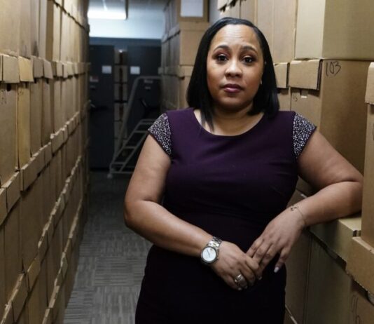 Judges approve special grand jury in Georgia election probe black woman resting arm against file boxes in a purple dress.