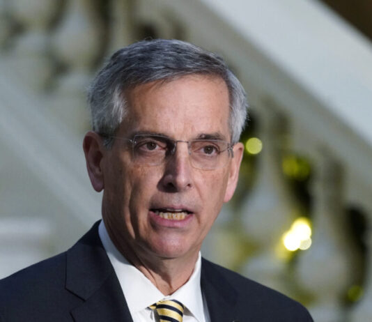 Raffensperger: Georgia buying new voter registration system White man with glasses with a suit and yellow tie.