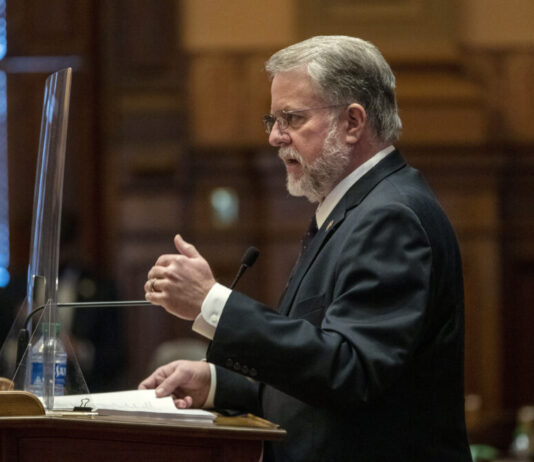 House passes Georgia amended budget with raises, tax rebates side photo of white man with grey hair and glasses, raising hand as he speaks