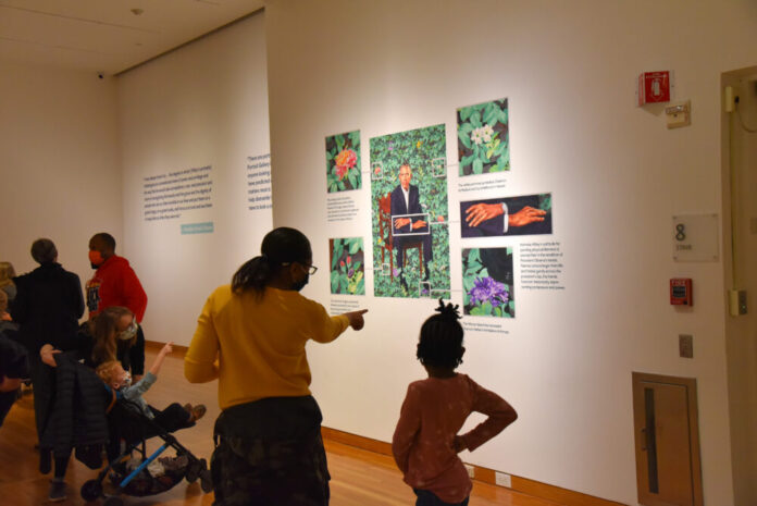 Mother and daughter looking at a portrait of Obama