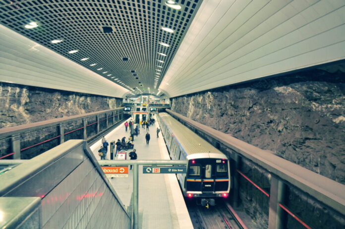 A view of an underground train station with people walking around.