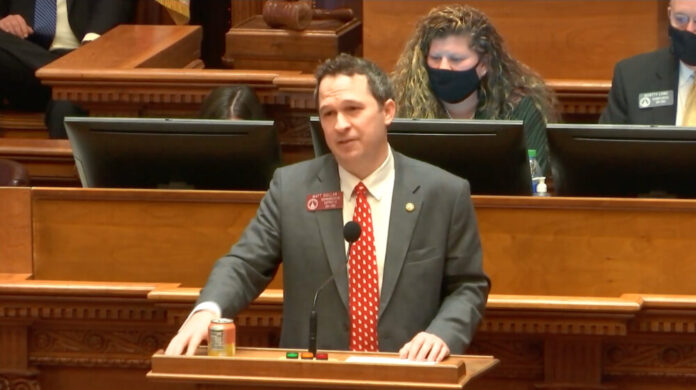 White man in gray suit and red tie speaking on Georgia House floor.
