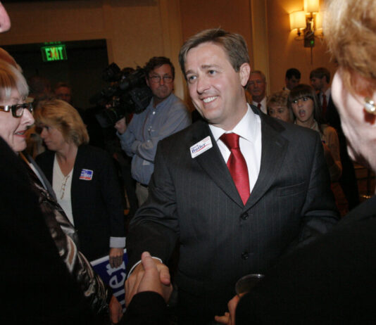 GOP’s Butler won’t seek 4th term as Georgia labor chief White man with short brown hair shaking hands with another man and smiling.