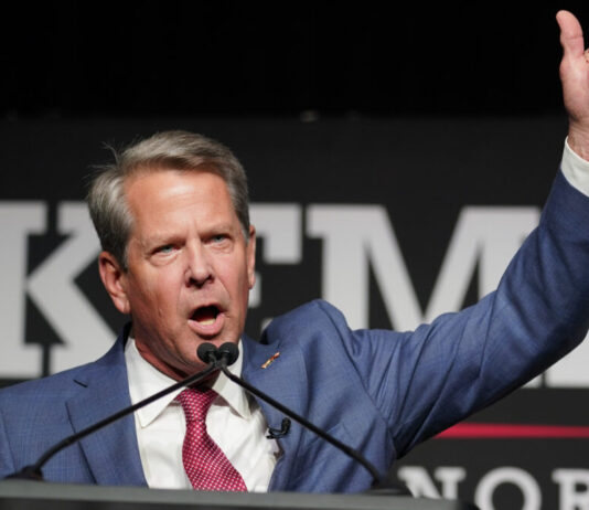 Trump rebuked with stinging losses in Georgia GOP contests white man in blue jacket and red tie speaks at microphones while giving thumbs up