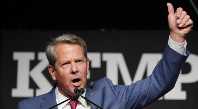 Trump rebuked with stinging losses in Georgia GOP contests white man in blue jacket and red tie speaks at microphones while giving thumbs up