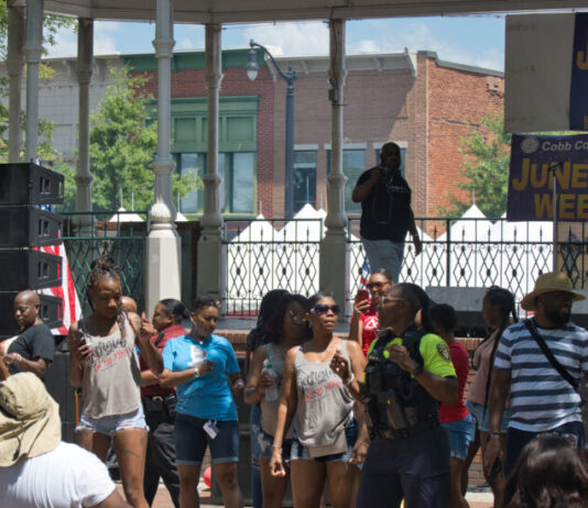 Cobb County NAACP holds 19th annual Juneteenth Celebration Juneteenth celebration at Marietta Square; group of people dance and celebrate in front of a pavilion on a sunny day