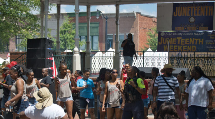 Cobb County NAACP holds 19th annual Juneteenth Celebration Juneteenth celebration at Marietta Square; group of people dance and celebrate in front of a pavilion on a sunny day