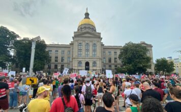 Appeals court says Georgia abortion law should take effect crowds of people with protest signs outside large stone building with gold dome and statue on top; abortion protest roe vs. wade reproductive rights