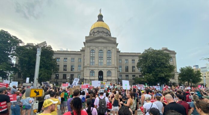 Appeals court says Georgia abortion law should take effect crowds of people with protest signs outside large stone building with gold dome and statue on top; abortion protest roe vs. wade reproductive rights