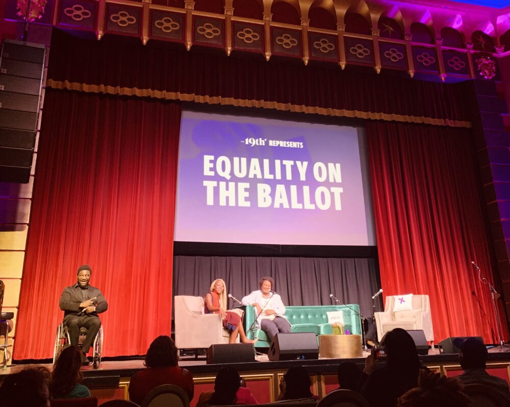 Three Black people on stage at an event surrounded by red curtains and a purple projector screen reading '19th presents Equality on the Ballot'