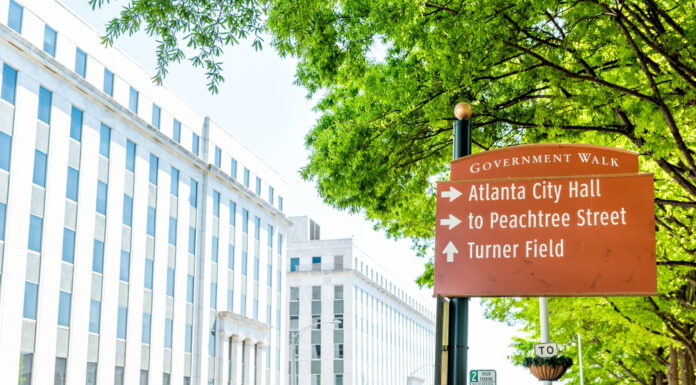 City approves new park for southwest Atlanta Large white and glass building surrounded by trees during a cloudy day with directional sign