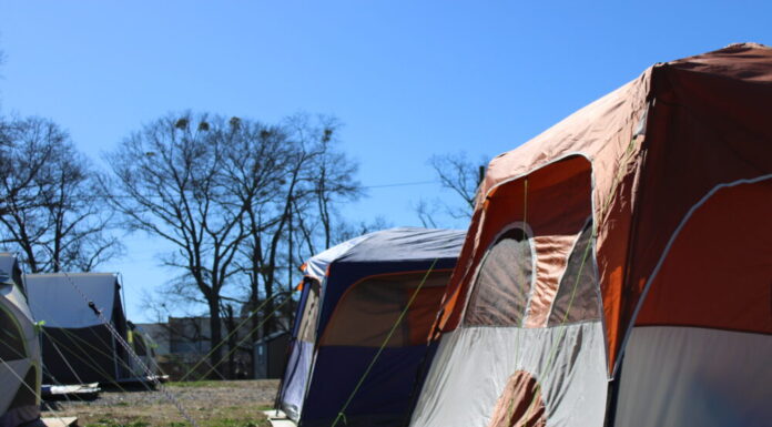 Georgia Senate passes bill targeting homelessness multiple camping tents in a field of green grass with trees and blue sky in background