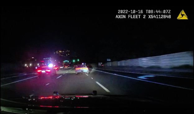 Still shot from camera footage of cars racing at high speed on the highway at night