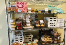 Georgia lawmakers look for ways to eradicate hunger across state. Metal shelf stocked with various food items against beige wall.