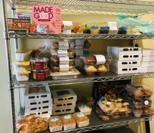 Georgia lawmakers look for ways to eradicate hunger across state. Metal shelf stocked with various food items against beige wall.