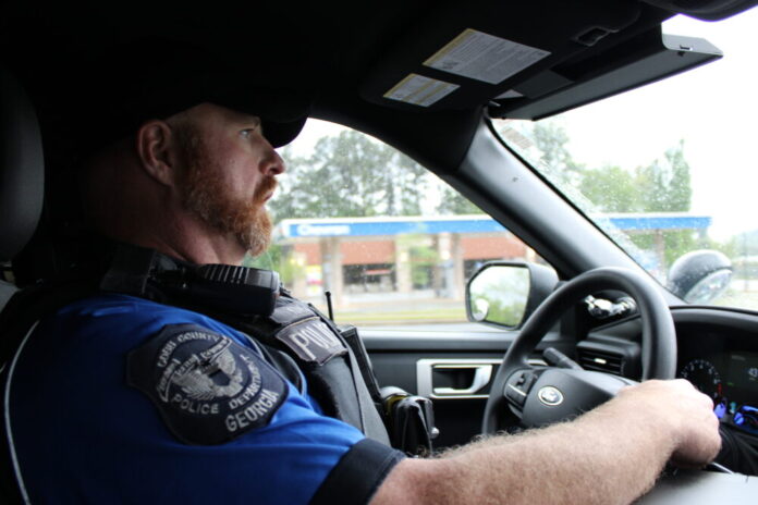 Police officer in uniform pictured inside his vehicle driving