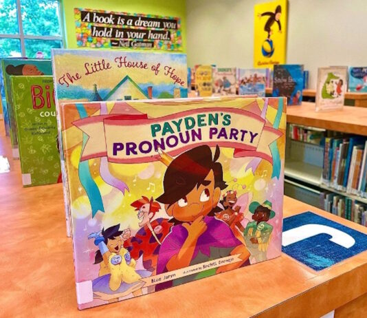 The potential impact of Cobb County book bans on education Children's book on a shelf surrounded by other books in a public library.