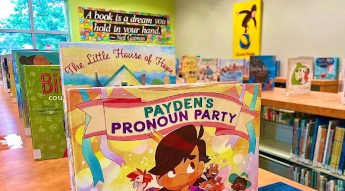 The potential impact of Cobb County book bans on education Children's book on a shelf surrounded by other books in a public library.